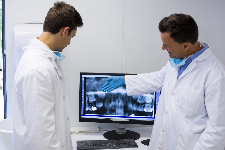 Dentistas visualizando seu sistema odontológico no computador 
