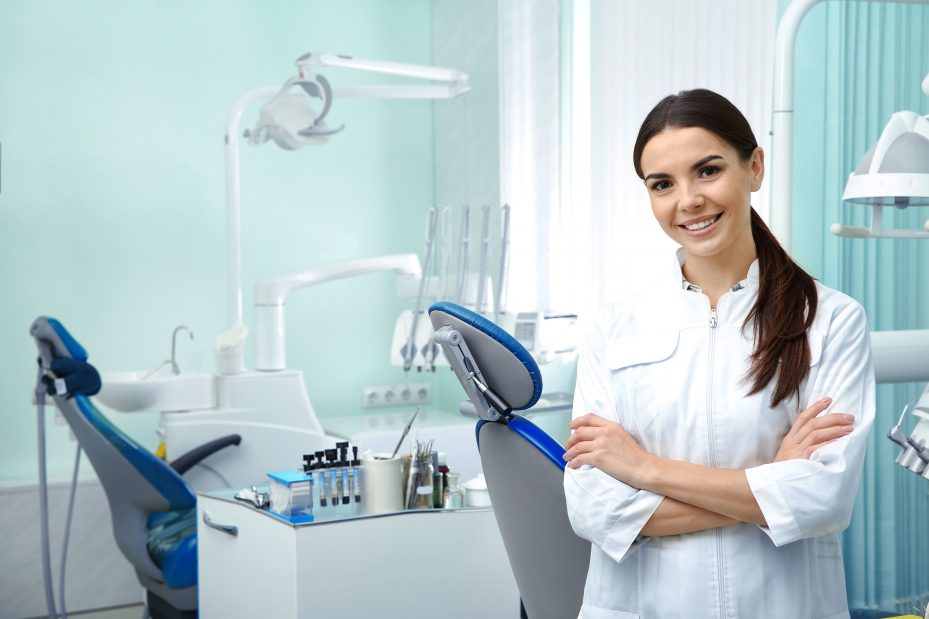 Dentista sorrindo em sua clínica